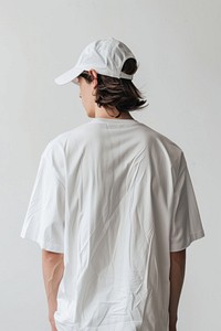 An oversized white t-shirt and white cap beachwear clothing apparel.