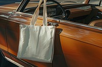 A white tote bag on car hood transportation accessories automobile.