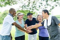 Diverse seniors stacking hands together