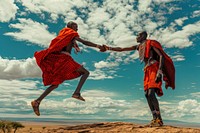 Celebratory handshake with a Maasai warrior jumping person clothing.