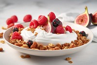 A bowl filled with Greek yogurt with figs sliced granola plate berry.