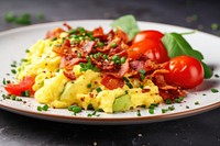 Scrambled eggs with bacon and avocado brunch plate food.