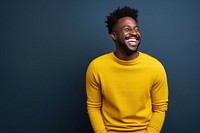 A Middle age black people waring yellow sweater laughing clothing knitwear.