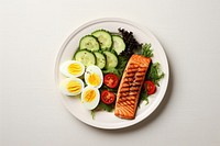 Avocado sliced and boiled eggs salmon plate food.