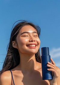 Happy southeast asian woman with smile and look away from camera bottle cosmetics perfume.