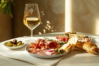 White plates featuring an assortment of Spanish charcuterie and bread on one plate glass food dish.