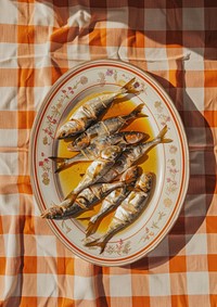 An oval platter of sprat fillets in oil was beautifully arranged on an orange and white checkered tablecloth plate herring sardine.