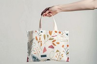 Hand holding patterned tote bag