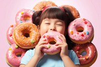 Child enjoying pink donuts