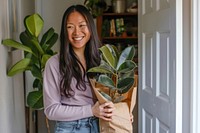 Happy woman holding houseplant