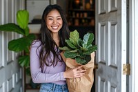 Woman holding potted plant indoors