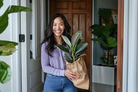 Smiling woman holding houseplant