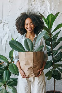 Smiling woman holding potted plant