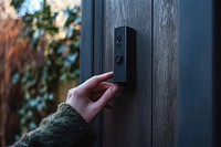 Hand using the doorbell technology security electronics.