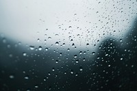 Raindrops dripping on glass background water atmosphere.