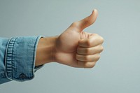 A hand of asian man with his thumb up thumbs approval positive.