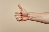 A hand of white man with his thumb up thumbs human encouragement.