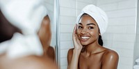 African American woman with clean healthy skin happy smiling mirror.