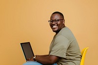 Man wearing glasses smile to a camera with a laptop man background sitting.