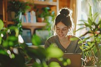 Woman working amidst indoor plants