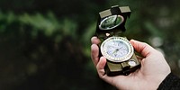 Hand holding a compass outdoors