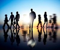 Silhouetted business people walking reflection