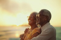 Portrait of a happy senior African-American couple laughing and looking at the sea outdoors portrait glasses.