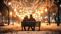 Couple sitting in bench romantic winter lights.