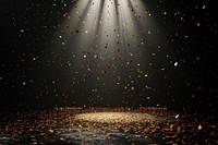 A black background with spotlights shining down confetti golden dark.