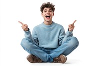 Excited young man sitting sweater background pointing.