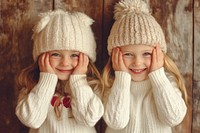 2 happy little girls friends with knitted hat sweaters hats background.