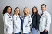 Five medical professionals doctors smiling coat.