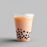 An isolated plastic cup of an ice boba pink milk tea drink beverage refreshing.