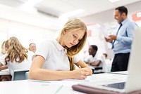 Teenage girl study in classroom. Teenage student girl learning from laptop at school with teacher teaching. Students in school classroom, learning. Teacher and students learning in classroom