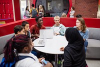 Diverse group of students studying together. Students with laptops, students discussing, students collaborating. Group of students in a modern setting. Diverse teenage students at modern high school.