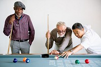 Three senior men, diverse ethnicities, playing pool. Senior men enjoying pool game including African American and Asian. Diverse senior men focused on pool table. Senior men bonding over pool game.