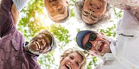 Group of diverse elderly friends, group hug, smile and laugh outdoors. Happy elderly diverse friends group hug outdoors, show happiness in diverse group. Diverse elderly friends happy smile and laugh