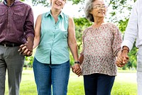 Group of diverse senior friends holding hands in park, unity and support. Diverse people senior group holding hands in unity. Diverse senior people group holding hands, give support friends in park. 