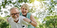 Happy elderly couple enjoy sunny day outdoors in park. Elderly couple smiling, elderly man with glasses, elderly woman with short hair, enjoy green park outdoors. Elderly couple in sunny nature park