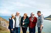 Group of elderly friends, men and women, stand together by the coast. Senior friends embrace, Elderly friends share moments at the coast. outdoor nature. Elderly friends have good time at coast