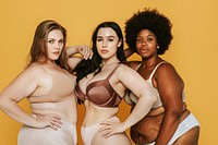 Three confident plus size diverse women in lingerie, showcasing body positivity against yellow background. Diverse women and body types, embracing confidence. Body positivity and confidence.