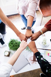 Diverse group of people, hands in a fist bump, teamwork, unity. Diverse hands, teamwork, unity. Group of people, unity. Diverse hands, unity, teamwork. Business team working together in office.