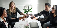 A diverse business group of four friends celebrate with red wine for achievement. Diverse business people enjoy a joyful toast for achievement. Business team celebrate toasting with red wine