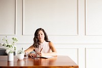 Young hispanic woman writing at a table. Woman with long hair writing notes. Woman at table with a notebook. Woman writing in a journal. Professional marketing execustive taking notes in an agenda.