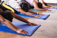 Diverse group of people practice yoga on mats. Yoga class with diverse people stretching. Diverse group of people in yoga class practice stretching on the floor. Yoga exercise  class in fitness studio