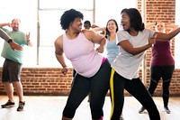 Diverse group of people in fitness dancing class. The fitness class features people dancing, smiling, and having fun. Diverse people exercising for well being. Diverse people training in a gym.