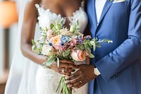 Black couple wedding holding flower.