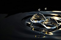 Transparent Water drop sunlight reflections water black background concentric.