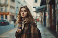 Young woman walking with a coffee on a city sidewalk photography portrait jacket.