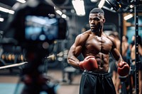 A boxer with video recording in foreground adult gym determination.